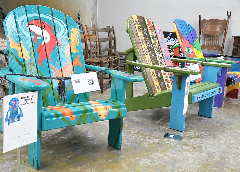 From left, “Under The Surface,” by Karen Holcomb, “Arkansas Natives,” by Roxy Rose Wallace, and “I See You,” by Carrie Gaston are displayed at Dryden Pottery during March's Gallery Walk. The chairs are included in the 15 that will be auctioned off on April 23. - Photo by Tanner Newton of The Sentinel-Record