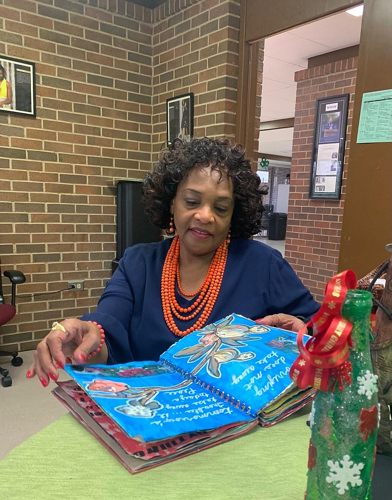 Vicki Parks looks through an art journal she created at the Sandflat center in Texarkana Arkansas.  (staff photo by Lori Dunn)