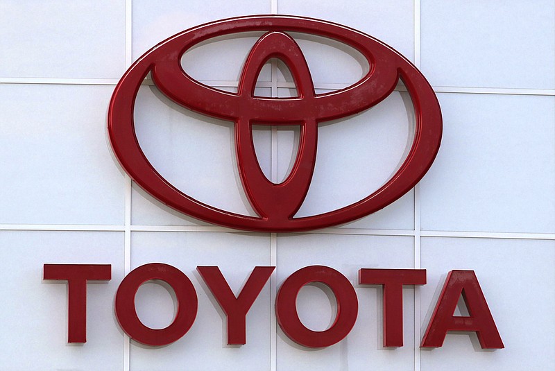 FILE - The Toyota logo on a dealership is seen in Manchester, N.H. on Aug. 15, 2019. Japan’s top automaker Toyota will scale back domestic production over the next three months because of a supply crunch in chips and other parts that have recently slammed the global auto industry.  (AP Photo/Charles Krupa, File)