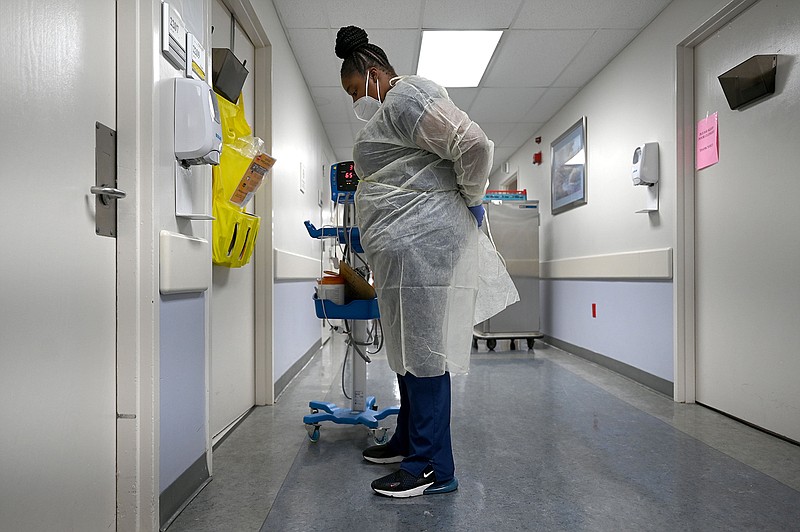 Sharaina Smiley, a Patient Care Technician at Jefferson Regional Medical Center, puts on PPE before entering a patient's room in the COVID ward of the hospital on Friday, Feb. 18, 2022. See more photos at arkansasonline.com/313covid/

(Arkansas Democrat-Gazette/Stephen Swofford)