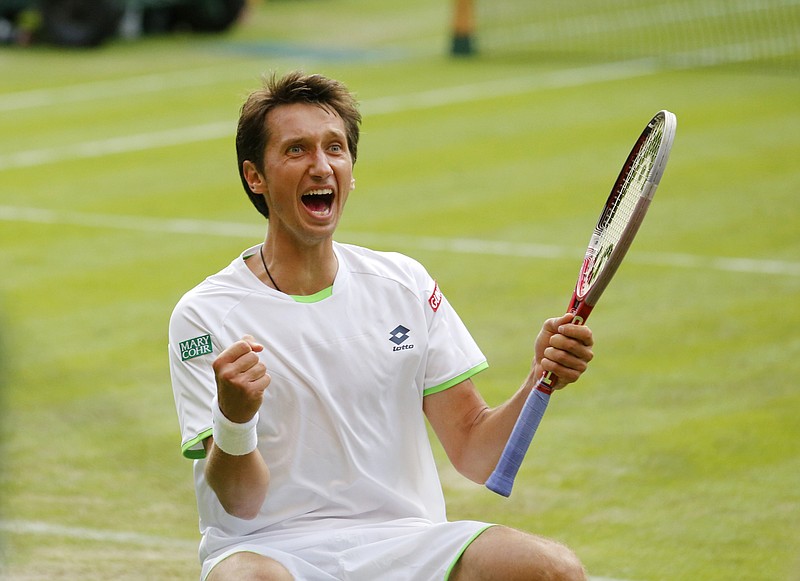 FILE -Sergiy Stakhovsky of Ukraine reacts as he wins against Roger Federer of Switzerland in their men's second round singles match at the All England Lawn Tennis Championships in Wimbledon, London, Wednesday, June 26, 2013. About 1 1/2 months after the last match of Sergiy Stakhovsky’s professional tennis career, the 36-year-old Ukrainian left his wife and three young children in Hungary and went back to his birthplace to help however he could during Russia’s invasion. (AP Photo/Anja Niedringhaus, File)