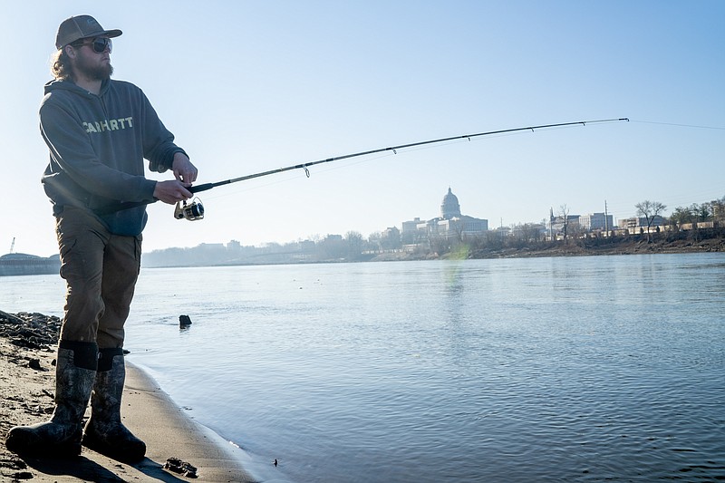 Ethan Weston/News Tribune Tanner Adamick tugs on his line to try and lure a fish to bite on Wednesday, March 16, 2022 at the Noren River Access. Adamick was trying to catch a paddlefish, also known as a spoonbill.