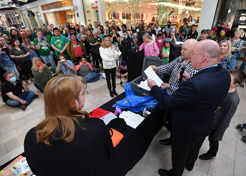 Jeff Bishop (right), senior general manager at the Northwest Arkansas Mall, reads Thursday, March 17, 2022, from a letter by then-Fayetteville Mayor Fred Hanna predicting what Fayetteville would be like in 2022 alongside Adam Raison, operations manager, and office manager Cindy Raleigh (left) during an unveiling of the contents of a time capsule that was buried beneath the floor of what was then the newly completed food court in 1997. The mall celebrated its 50th anniversary with the unveiling, and said it plans to bury another time capsule to be opened in 2047. Visit nwaonline.com/220318Daily/ for today's photo gallery.
(NWA Democrat-Gazette/Andy Shupe)