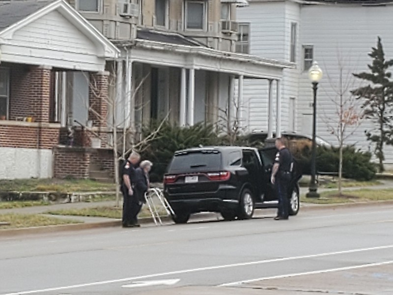 Members of the Jefferson City Police Department escort Barbara Buescher from her home on East Capitol Avenue on Friday morning. She had failed to comply with an order for her to leave because city inspectors found the home to be dangerous to live in.