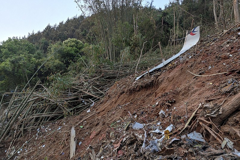 In this photo taken by mobile phone released by Xinhua News Agency, a piece of wreckage of the China Eastern's flight MU5735 are seen after it crashed on the mountain in Tengxian County, south China's Guangxi Zhuang Autonomous Region on Monday, March 21, 2022. A China Eastern Boeing 737-800 with 132 people on board crashed in a remote mountainous area of southern China on Monday, officials said, setting off a forest fire visible from space in the country's worst air disaster in nearly a decade. (Xinhua via AP)