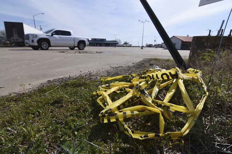 Crime scene tape lies on the ground, Sunday, March 20, 2022 at the scene where a shooting that left over 20 injured and one dead occurred Saturday night in Dumas, Ark. (Staci Vandagriff/The Arkansas Democrat-Gazette via AP)