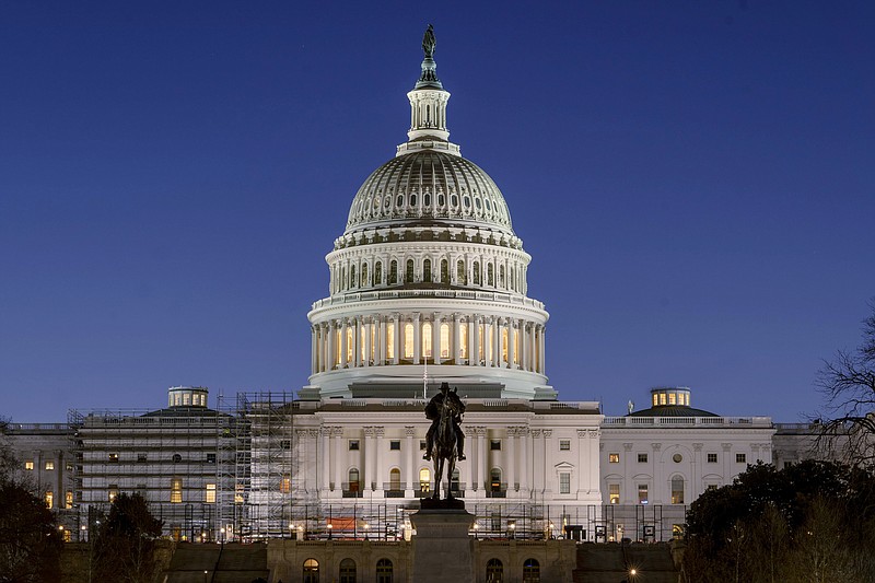 FILE - The U.S. Capitol building is seen before sunrise on Capitol Hill in Washington, Monday, March. 21, 2022. With an urgent funding request stuck in Congress, the Health Resources and Services Administration says it can no longer cover medical bills for COVID tests and treatments for uninsured people and will stop taking claims at midnight Tuesday. (AP Photo/Gemunu Amarasinghe, File)