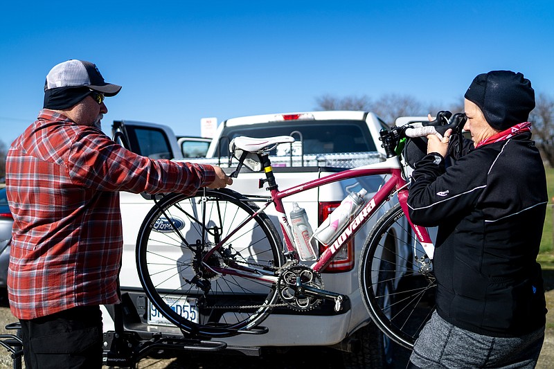 Tony Maiuro and Maggie George pull a bike off the rack a head of the first community bike ride of the season on Saturday, March 26, 2022 at the North Jefferson Recreation Area. The pair have been riding together for 18 years. (Ethan Weston/News Tribune photo)