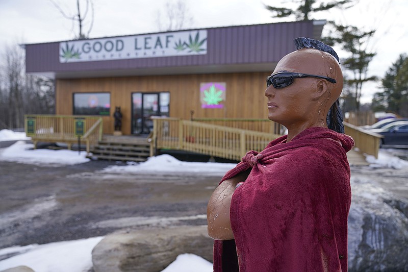 A statue of a Mohawk warrior is displayed in front of the Good Leaf Dispensary on the reservation Mohawks call Akwesasne, Monday, March 14, 2022, in St. Regis, N.Y.  As New York inches toward launching an adult marijuana market, sales are flourishing on some Native American territory in the state. Shops selling buds and edibles dot the main road through the U.S. side of St. Regis Mohawk Reservation by the Canadian border.  (AP Photo/Seth Wenig)