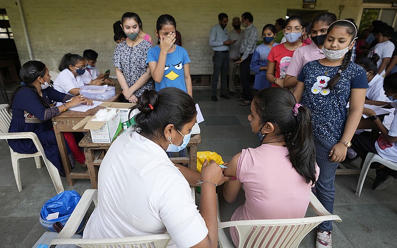A health worker administers the Corbevax vaccine to a student during a Vaccination drive for 12 to 14 age group children at a school in Ahmedabad, India, Friday, March 25, 2022. (AP Photo/Ajit Solanki)