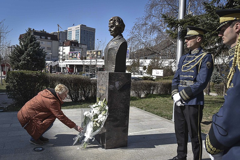 A woman lays a bouquet of flowers at the foot of a statue of former U.S. Secretary of State Madeleine Albright, in Pristina, Kosovo, Thursday, March 24, 2022. A monument in Kosovo, a snake named after her in Serbia. Madeleine Albright was either loved or hated in the Balkans for her pivotal role during the southern European region's wars of the 1990s. Following the former U.S. secretary of state's death on Wednesday at age 84, how her legacy is viewed from the Balkans mostly depends on whether one was on the receiving or triggering end of the bloody breakup of the former Yugoslavia. (AP Photo/Visar Kryeziu)