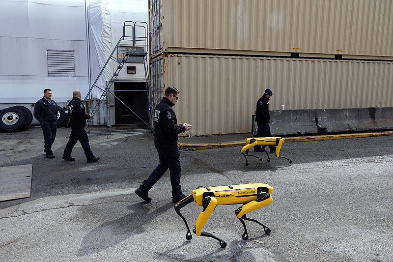 Members of the New York Fire Department’s robotics team practices with robotic dogs, which operate remotely with a device similar to a video game controller, at the department’s training facility on Randall’s Island in New York City on March 10, 2022. The department purchased two Spot robots built by Boston Dynamics and plans to use them to venture into hazardous situations. (Mostafa Bassim/The New York Times)