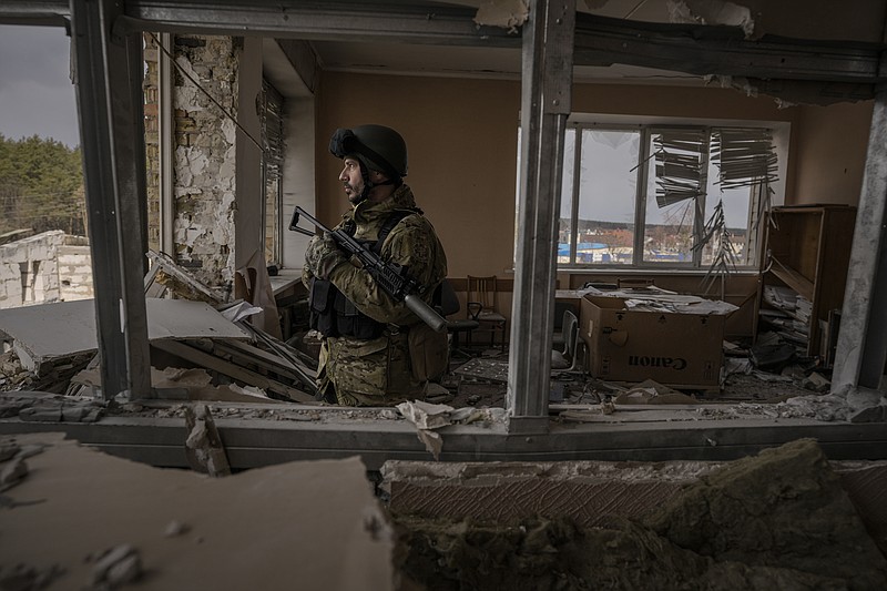 A Ukrainian serviceman stands in a heavily damaged building in Stoyanka, Ukraine, Sunday, March 27, 2022. Ukrainian President Volodymyr Zelenskyy accused the West of lacking courage as his country fights to stave off Russia's invading troops, making an exasperated plea for fighter jets and tanks to sustain a defense in a conflict that has ground into a war of attrition. (AP Photo/Vadim Ghirda)