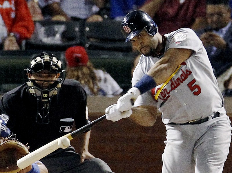 FILE - St. Louis Cardinals' Albert Pujols hits a solo home run during the ninth inning of Game 3 of baseball's World Series against the Texas Rangers in Arlington, Texas, in this Saturday, Oct. 22, 2011, file photo. Pujols has returned to the Cardinals, finding a home in the place where he became one of baseball's most powerful sluggers. The 42-year-old emerged from beyond the right field wall at the Cardinals' spring training complex between the first and second innings of an exhibition game against Houston on Monday, March 28, 2022. (AP Photo/Eric Gay, File)