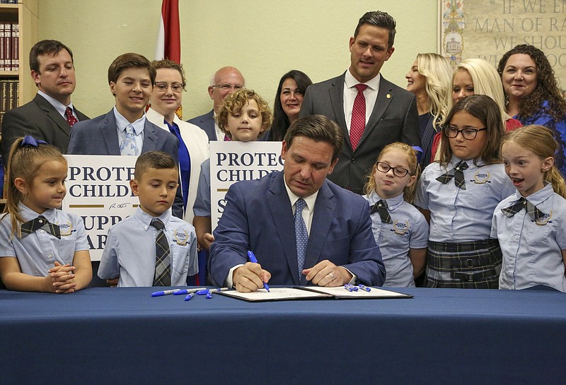 Florida Gov. Ron DeSantis signs the Parental Rights in Education bill at Classical Preparatory school Monday, March 28, 2022 in Shady Hills, Fla. (Douglas R. Clifford/Tampa Bay Times via AP)