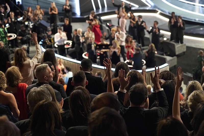 The audience signs the word "applause" as the cast and crew of "CODA" accept the award for best picture at the Oscars on March 27, 2022, at the Dolby Theatre in Los Angeles. The three Oscar wins for the film “CODA” has provided an unprecedented feeling of affirmation to people in the Deaf community. (AP Photo/Chris Pizzello, File)