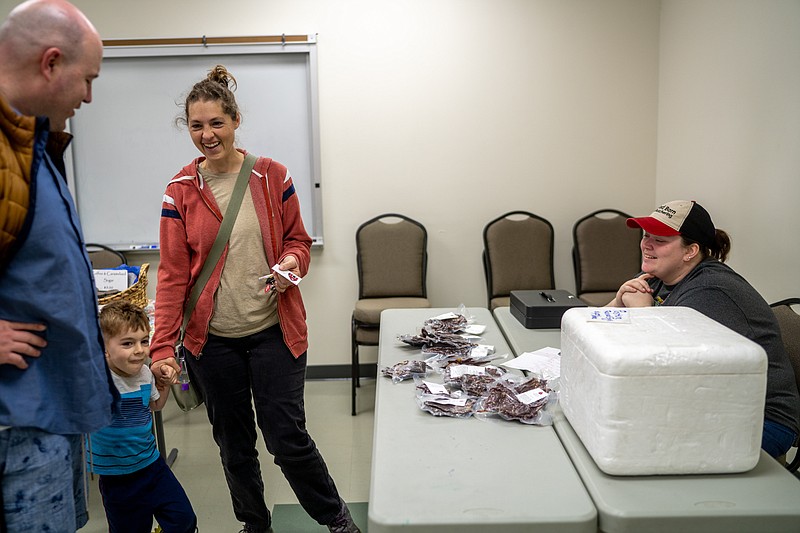 Sara and Mike Dodson and their son Raph talk with Liz Rothove of Red Barn Butchering on Saturday, April 2, 2022, at the Lincoln University Farmers Market in Jefferson City. The Dodson’s grow microgreens. “We are getting a feel for what’s in the area,” Mike Dodson said. (Ethan Weston/News Tribune photo)