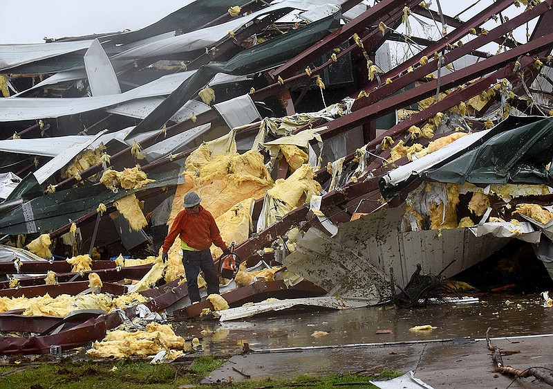 A worker walks Wednesday March 30 2022 among the remains of the George Elementary gym in Springdale. Parts of the school were also damaged by the tornado. Go to nwaonline.com/220331Daily/ to see more photos.
(NWA Democrat-Gazette/Flip Putthoff)