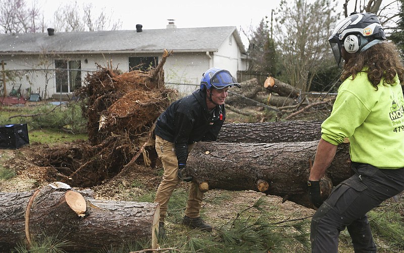 Benjamin Churchwell (from left) and Randy Thompson of Monster Tree Service remove debris, Thursday, March 31, 2022 from a residential property along Don Tyson Parkway east of Turner St. in Springdale. Check out nwaonline.com/220401Daily/ and nwadg.com/photos for a photo gallery.

(NWA Democrat-Gazette/Charlie Kaijo)