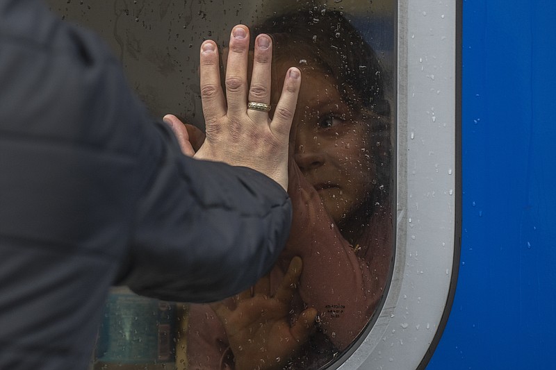 A girl inside a train reacts as she says goodbye to relatives at the train station in Odesa, before she and members of her family escape the war in Ukraine to Poland, on Saturday, April 2, 2022. (AP Photo/Petros Giannakouris)