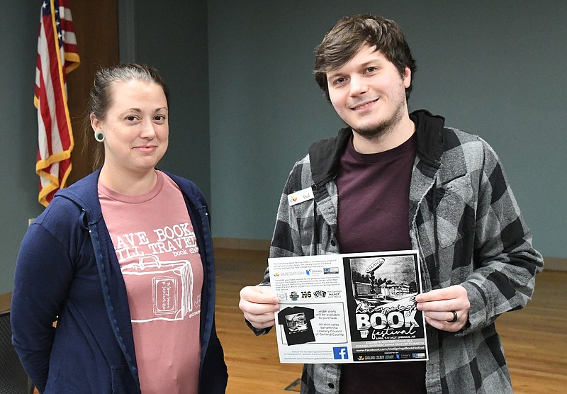 Erin Baber, left, Garland County Library marketing manager, and Paul Kagebein, adult services programmer, display an advertisement for the Hot Springs Book Festival, which starts Thursday. - Photo by Tanner Newton of The Sentinel-Record