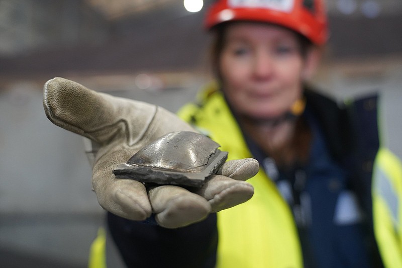 Susanne Rostmark, research leader, LKAB, holds a piece of hot briquetted iron ore made using the HYBRIT process nearby the venture?s pilot plant in Lulea, Sweden on Feb. 17, 2022. The steel-making industry is coming under increasing pressure to curb its environmental impact and contribute to the Paris climate accord, which aims to cap global warming at 1.5 degrees Celsius (James Brooks via AP)