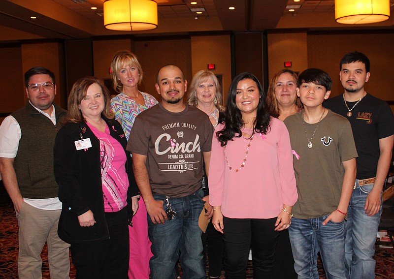 Silvia Gomez, breast cancer survivor (fourth from right), is joined by family and friends, Eric Gomez (from left), Lisa Nims, Dana Creek, Jose Salinas, Alice Corder, Gricelda Gomez, Brandon Gomez and Monquil Gomez at the Komen Ozark Pink Ribbon Luncheon on March 17 at the Northwest Arkansas Convention Center in Springdale. Silvia was a guest speaker who shared her survivor story with luncheon guests. 
(NWA Democrat-Gazette/Carin Schoppmeyer)