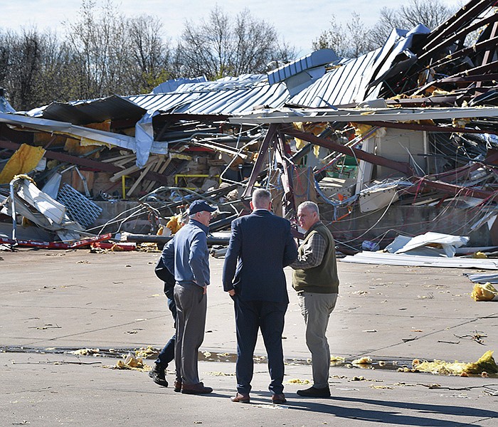 Gov. Asa Hutchinson (left) speaks Thursday, April 7, 2022, with officials in front of piles of debris after touring tornado damage at Nilfisk-Advance in Springdale. The business was heavily damaged after a tornado touched down early in the morning of March 30. Visit nwaonline.com/220408Daily/ for today's photo gallery. 
(NWA Democrat-Gazette/Andy Shupe)