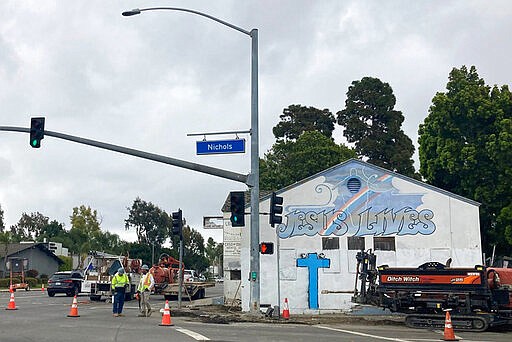 Construction crews work around Wintersburg Japanese Presbyterian Church, right, in Huntington Beach, Calif., on Thursday, March 31, 2022. This historic church sits on 4.5-acres that, according to the National Trust for Historic Preservation, is among the only surviving Japanese American properties acquired before California enacted the Alien Land Law in 1913 that barred Asian immigrants from owning land. (Alejandra Molina/Religion News Service via AP)