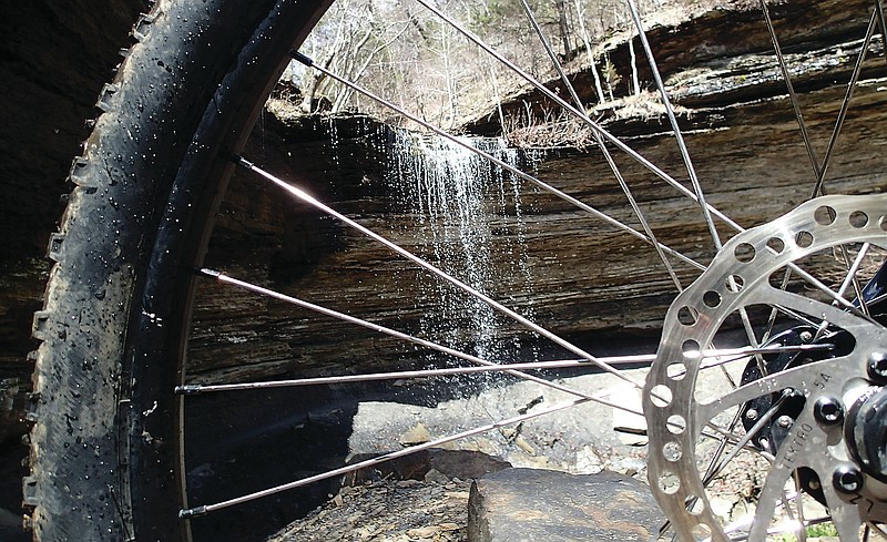 A spokes-eye view of Yellow Rock Falls, a popular riding destination on April 2 2022 at the 33rd annual Ozark Mountain Bike Festival. A mountain bike trail curves behind the waterfall. It's reached via the Gold Brick trail near Campground A at Devil's Den State Park.
(NWA Democrat-Gazette/Flip Putthoff