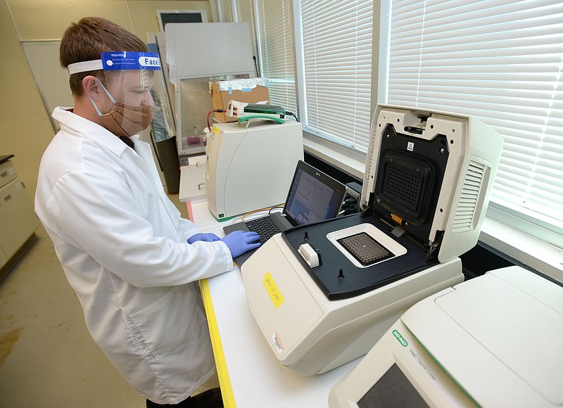 Aaron Long, a graduate student at the University of Arkansas from Kansas City, Mo., demonstrates Wednesday, Sept. 30, 2020, part of the process that he, Wen Zheng, an associate professor in the Department of Civil Engineering at the University of Arkansas, and other researchers are using to test waste water for the presence of the coronavirus that causes covid-19 in the Cato Springs Research Center in Fayetteville. (NWA Democrat-Gazette/Andy Shupe)