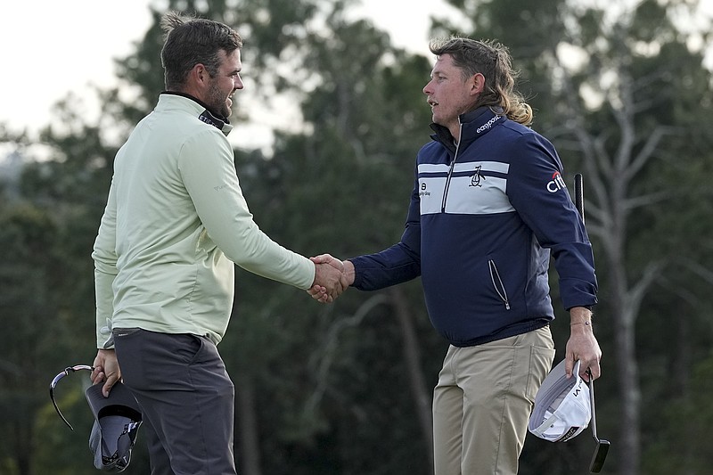 Corey Conners, left, of Canada, shakes hands with Cameron Smith, of Australia, on the 18th green following their third round at the Masters golf tournament on Saturday, April 9, 2022, in Augusta, Ga. (AP Photo/David J. Phillip)