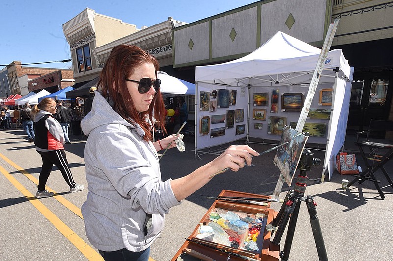 April Burris of Clinton paints a picture she hoped to sell at her booth on Saturday April 9 2022 in the art wing of the Bentonville Farmers Market in downtown Bentonville. The market features an array of items including produce, flowers, hand-made furniture and art works of all types. 
(NWA Democrat-Gazette/Flip Putthoff)