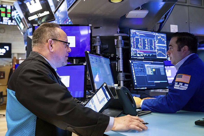 In this photo provided by the New York Stock Exchange, trader Robert Arciero, left, works on the trading floor, Monday, April 11, 2022. Stocks fell in afternoon trading on Wall Street Monday as the market extends a losing streak from last week. (David L. Nemec/New York Stock Exchange via AP)