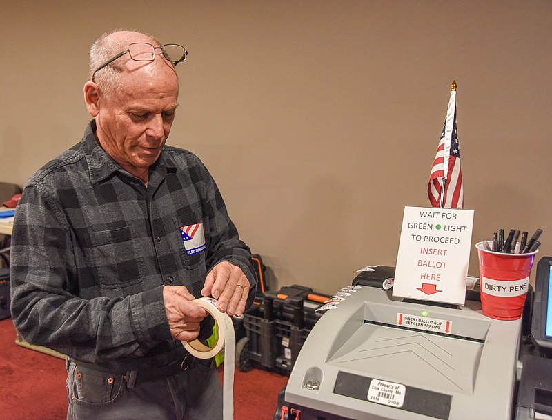 Julie Smith/News Tribune
J.P. Van Nostrand  peels "I Voted" stickers from the roll and places them around the machine so that voters can easily take one after casting their ballot. Van Nostrand was working at Jefferson/CC General in Southridge Baptist Church on April 5.
