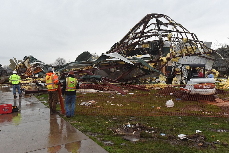 Workers begin cleanup Wednesday March 30 2022 at the George Elementary gym in Springdale. The school was also damaged. Go to nwaonline.com/220331Daily/ to see more photos.
(NWA Democrat-Gazette/Flip Putthoff)