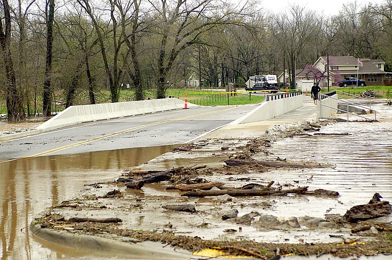 Westside Eagle Observer/RANDY MOLL
Heavy rains on the morning of April 13 caused Flint Creek to overflow its banks and close the new bridge on Dawn Hill East Road in Gentry temporarily, with water running over the bridge aprons on both sides of the creek.