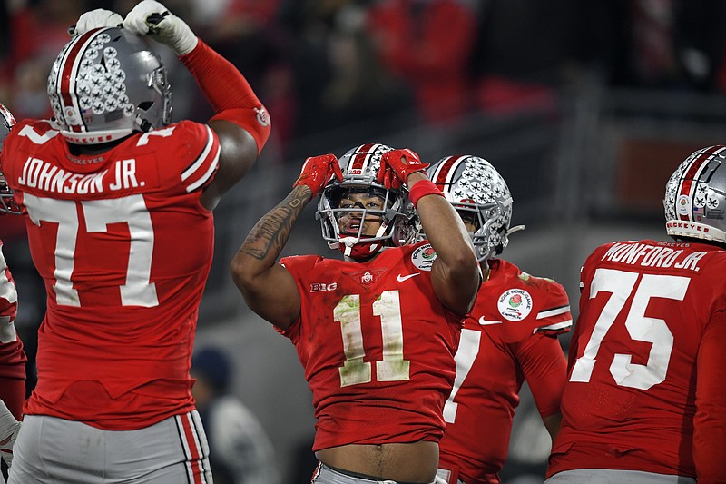FILE - Ohio State wide receiver Jaxon Smith-Njigba (11) celebrates his touchdown catch with offensive lineman Paris Johnson Jr. (77) during the second half in the Rose Bowl NCAA college football game against Utah on Jan. 1, 2022, in Pasadena, Calif. Smith-Njigba, the starting slot receiver for the Buckeyes as a sophomore last year, stepped out of the shadow of the more established receivers to pace the Buckeyes with 95 catches and 1,606 yards. (AP Photo/John McCoy, File)