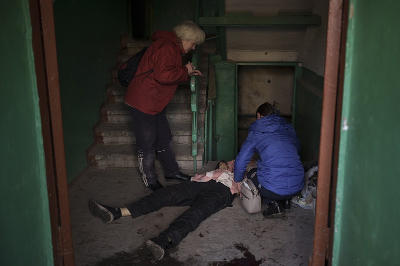 Nina Shevchenko, right, mourns next to the body of her 15-year-old son Artem Shevchenko, who was killed in a Russian attack in Kharkiv, Ukraine, Friday, April 15, 2022. (AP Photo/Felipe Dana)
