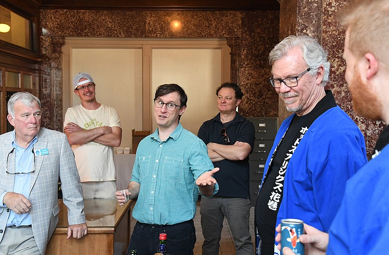 Ben Bell, center, blue button down shirt, speaks with Robert Zunick and Corey Alderdice at a sake tasting.