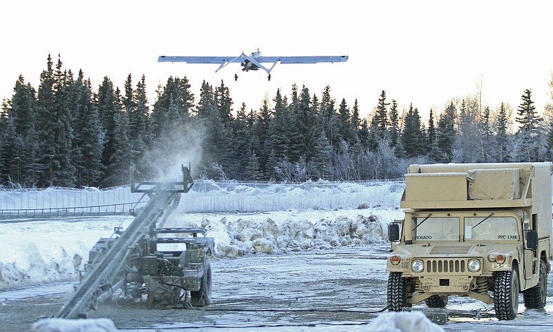 FILE - In this Jan. 30, 2014 photo, an RQ7 Shadow unmanned aircraft flies from its pneumatic catapult launcher at Joint Base Elmendorf-Richardson in Anchorage, Alaska. U.S. military bases in the Arctic and sub-Arctic are failing to harden their installations against long-term climate change as required, even though soaring temperatures and melting ice already are cracking base runways and roads and worsening flood risks up north, the Pentagon's watchdog office said April 14, 2022. (AP Photo/Dan Joling, File)