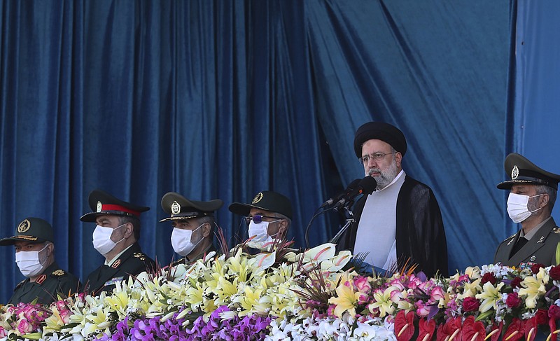 In this photo released by the official website of the office of the Iranian Presidency, President Ebrahim Raisi, second right, reviews the army troops parade commemorating National Army Day, as he is accompanied by armed forces commanders in front of the mausoleum of the late revolutionary founder Ayatollah Khomeini Monday, April 18, 2022, outside Tehran, Iran. Raisi warned that Israel will be targeted by his country's armed forces if it makes "the tiniest move" against Iran. (Iranian Presidency Office via AP)