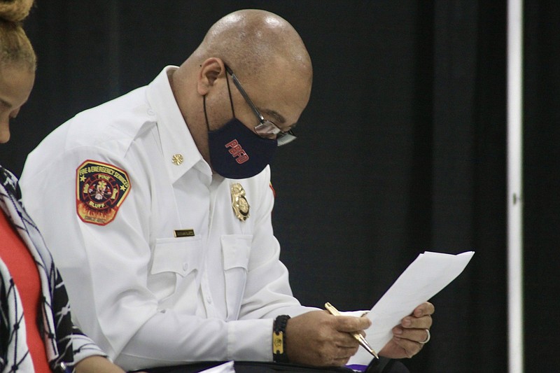 The city council passed a resolution that will allow Fire Chief Shauwn Howell to purchase a Pierce Ascendant Tower truck and one Pierce Enforcer pump truck. Howell follows along as the resolution is read aloud. (Pine Bluff Commercial/Eplunus Colvin)