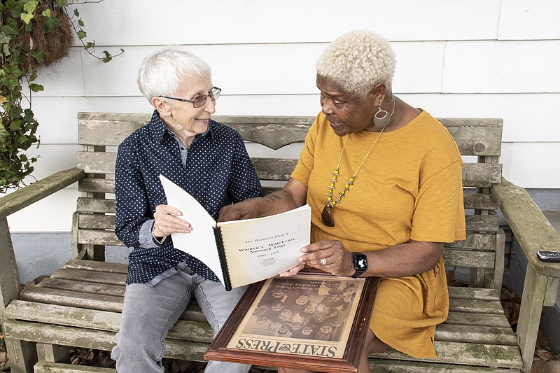 Suzanne Pharr and Damita Jo Marks, former board members of The Women’s Project, look at a framed cover of the State Press which features The Women’s Project Board on Thursday at Pharr’s Little Rock home. (Arkansas Democrat- Gazette/Cary Jenkins)