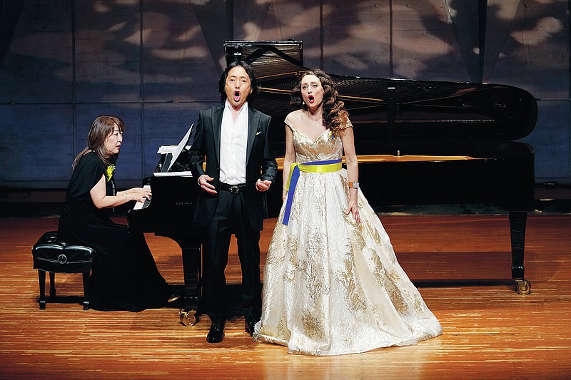 Oksana Stepanyuk, right, a Ukrainian soprano opera singer living in a Tokyo suburb, and Masafumi Akikawa, a Japanese tenor singer, sing as Sayaka Kojima plays piano during a charity concert in Kokubunji, west of Tokyo, Thursday, April 14, 2022. Stepanyuk, who has been singing in Japan for two decades, is dedicating her latest series of concerts to peace. (AP Photo/Hiro Komae)