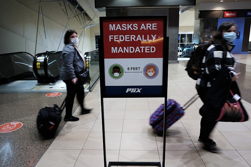 People walk through Sky Harbor International Airport, in Phoenix, on Dec. 18, 2021. (Spencer Platt/Getty Images/TNS)