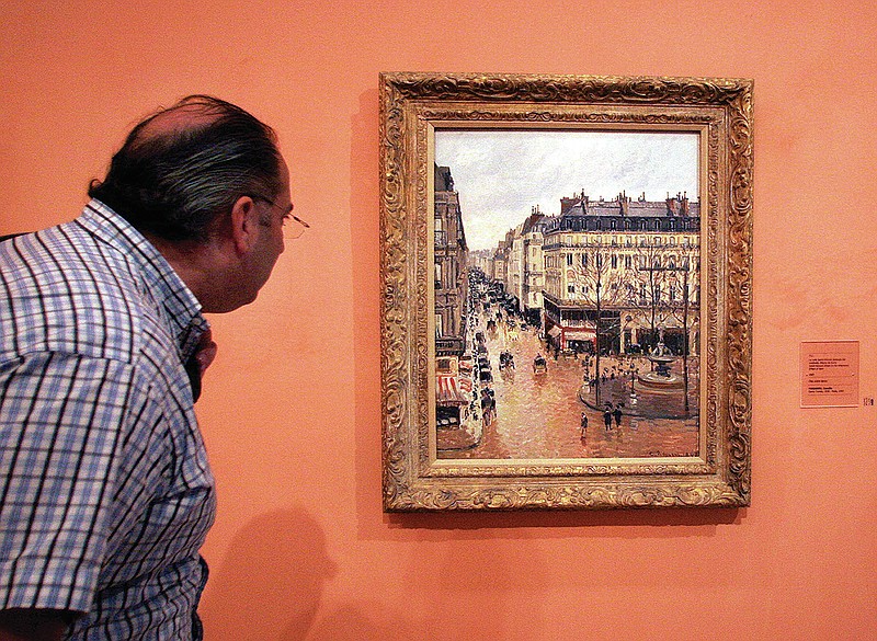 FILE - This May 12, 2005 file photo shows an unidentified visitor viewing the Impressionist painting called "Rue St.-Honore, Apres-Midi, Effet de Pluie" painted in 1897 by Camille Pissarro, on display in the Thyssen-Bornemisza Museum in Madrid. Lilly Cassirer surrendered her family's priceless Camille Pissarro painting to the Nazis in exchange for safe passage out of Germany during the Holocaust. The Supreme Court is hearing the case about the stolen artwork. (AP Photo/Mariana Eliano, File)