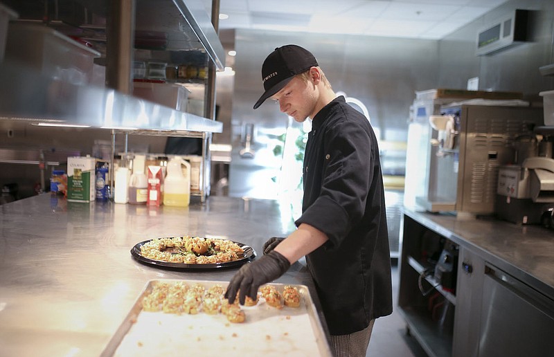 Bentonville Ignite student Joshua Shanks plates a tomato feta crustini with a fig glaze, Thursday, April 21, 2022 at Brightwater in Bentonville. Bentonville Ignite culinary students will be graduating next month and going into the workforce, to college or to additional technical training. Check out nwaonline.com/220422Daily/ and nwadg.com/photos for a photo gallery.

(NWA Democrat-Gazette/Charlie Kaijo)