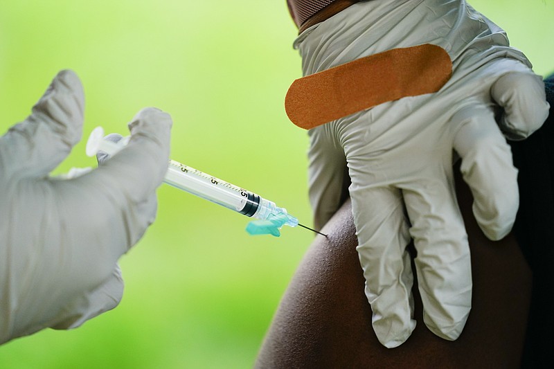 FILE - A health worker administers a dose of COVID-19 vaccine during a vaccination clinic in Reading, Pa. COVID-19 vaccinations are at a critical juncture as companies test whether new approaches like combination shots or nasal drops can keep up with a mutating coronavirus — even though it’s not clear if any change is needed. (AP Photo/Matt Rourke, File)