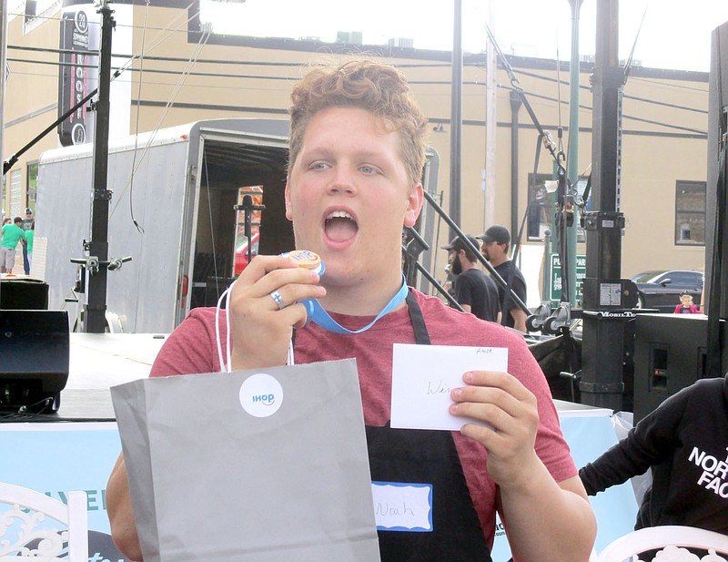 Marc Hayot/Herald-Leader Noah Race attempts to bite into his pancake medal at the pancake eating contest held during the Dogwood Festival. Race won the adult division of the pancake eating contest. When asked for a comment Race simply said "I love Siloam."